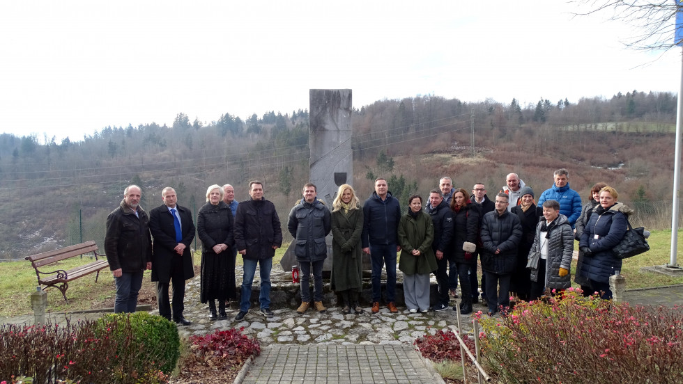 Skupinska fotografija predstavnikov uprave za vojaško dediščino pred spominskim obeležjem