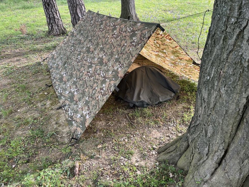 Šotorsko krilo postavljen v obliki šotora med drevesi na travniku