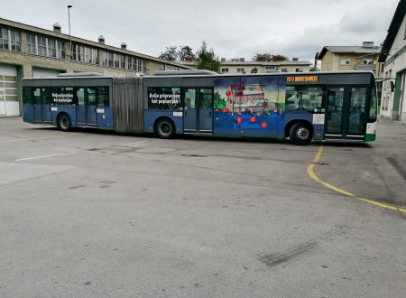 Na fotografiji je vidna desna stran zgibnega avtobusu, ki stoji na praznem parkirišču. Na avtobusu je ilustracija hiše in garaže, ki sta delno poplavljeni. Na avtobusu sta dva manjša bela napisa Bolje pripravljen kot poplavljen.