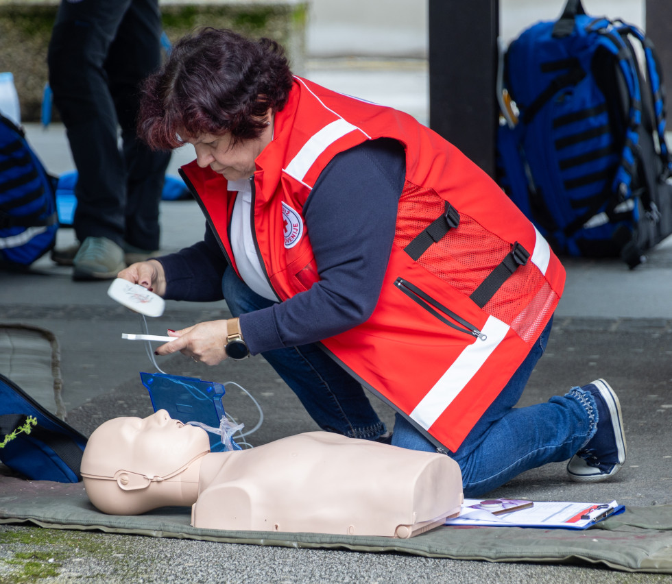 Bolničarka Rdečega križa Slovenije na lutki izvaja temeljne postopke oživljanja.