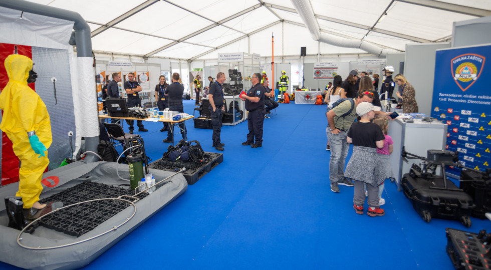 notranji razstavni prostor v šotoru z razstavljavci in obiskovalci ter razstavljeno opremo