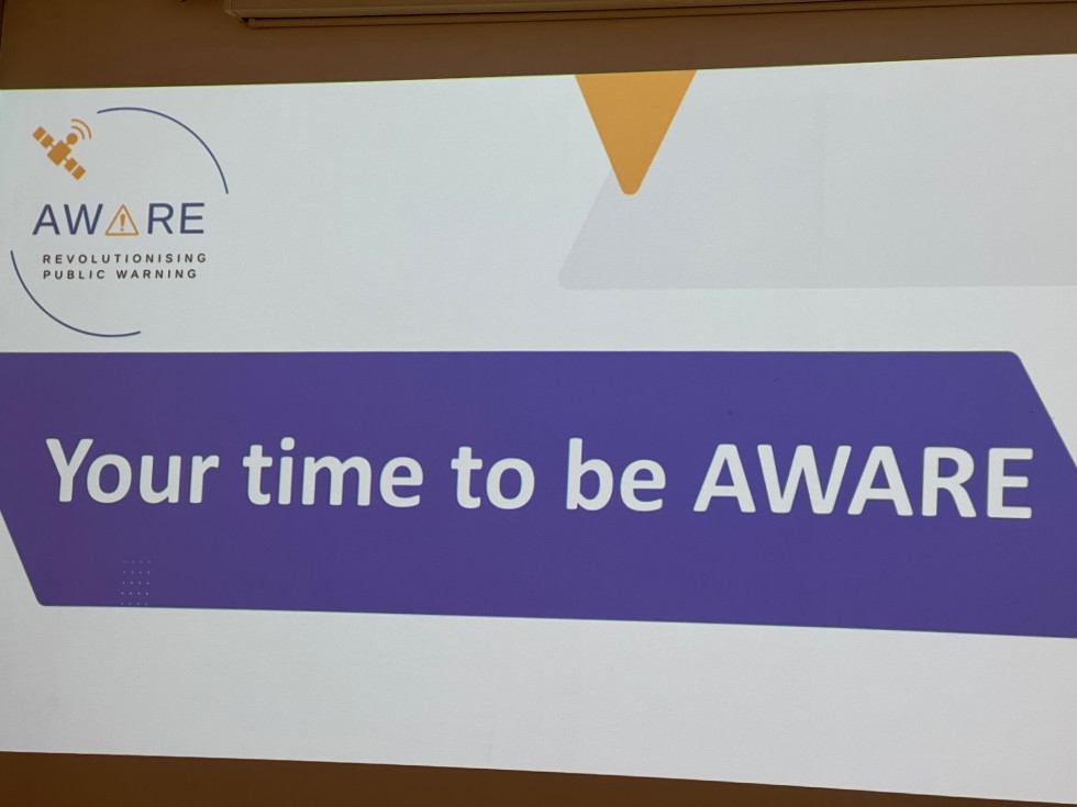 Bel napis na vijolični podlagi: Your time to be AWARE.
