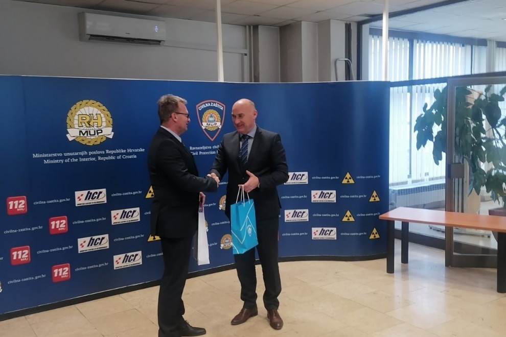 Generalna direktorja se rokujeta pred platnom v medijskem središču.