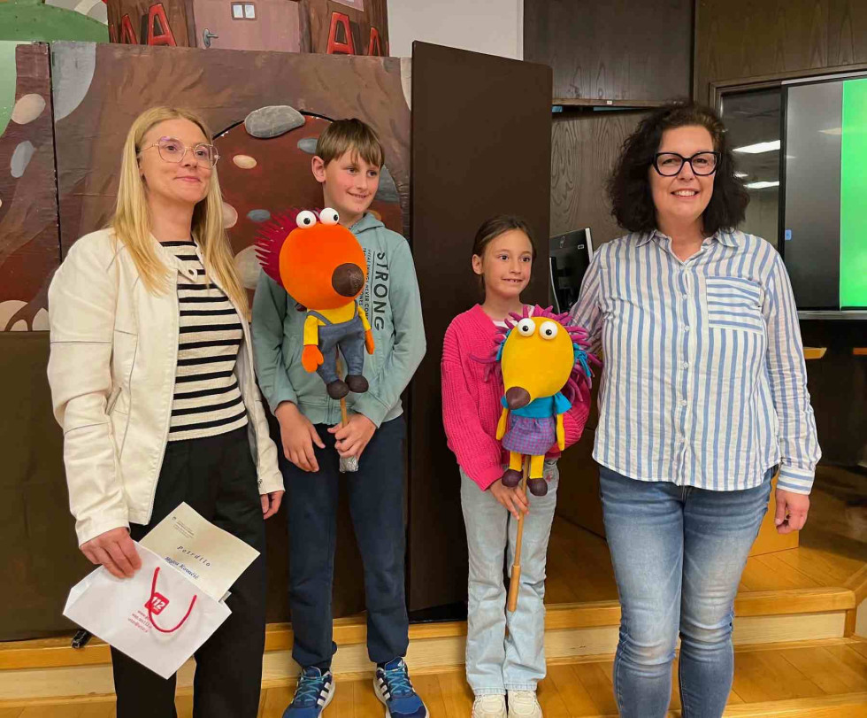 Od leve proti desni Mojca Kovačič, mentorica in Jurij Drole, državni nagrajenec iz OŠ Notranjski odred Cerknica,  Taja Radivo, državna nagrajenka iz OŠ Košana ter Amedeja Oven predsednica regijske komisije za izbor najboljših del.