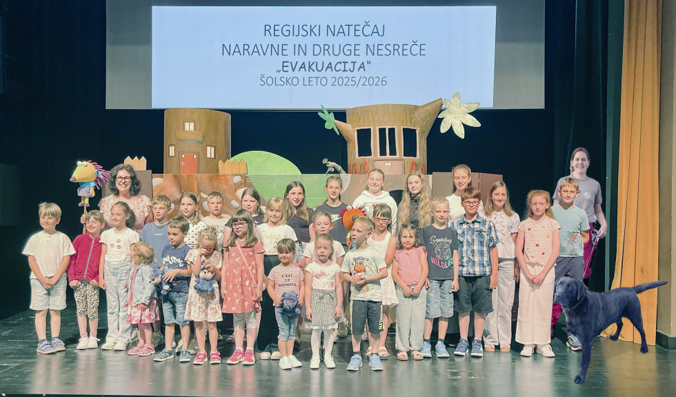 Iz leve proti desni Amedeja Oven, regijska natečajna komisija, otroci iz regijskega natečaja, predstavnica Kluba vodnikov reševalnih psov Postojna z enim od psov