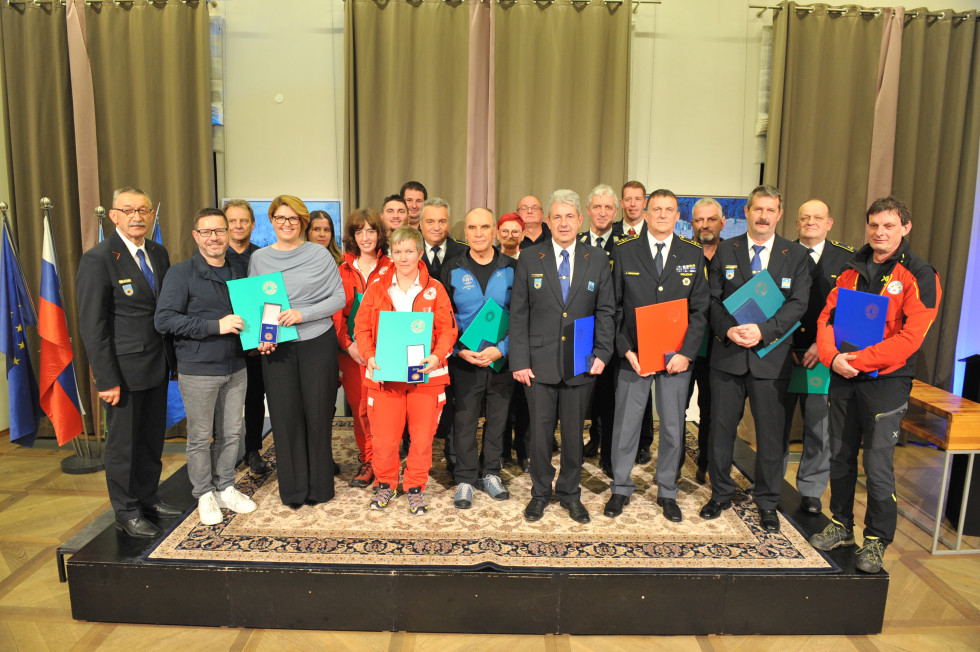 Skupina prejemnikov priznanj stoji na odru.