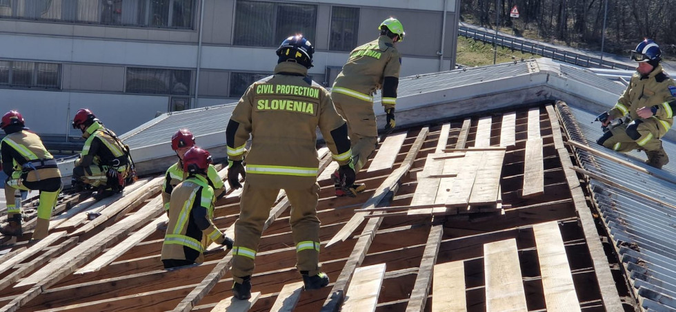 Gasilci prekrivajo streho.