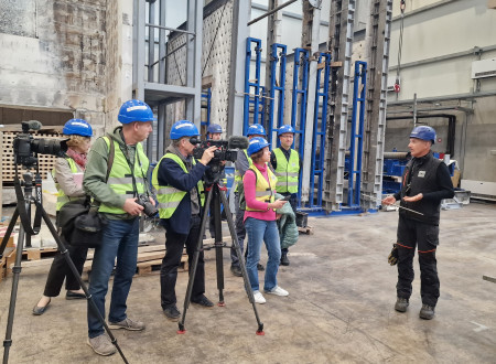 Ljudje v odsevnikih in čeladah v požarnem laboratoriju Logatec