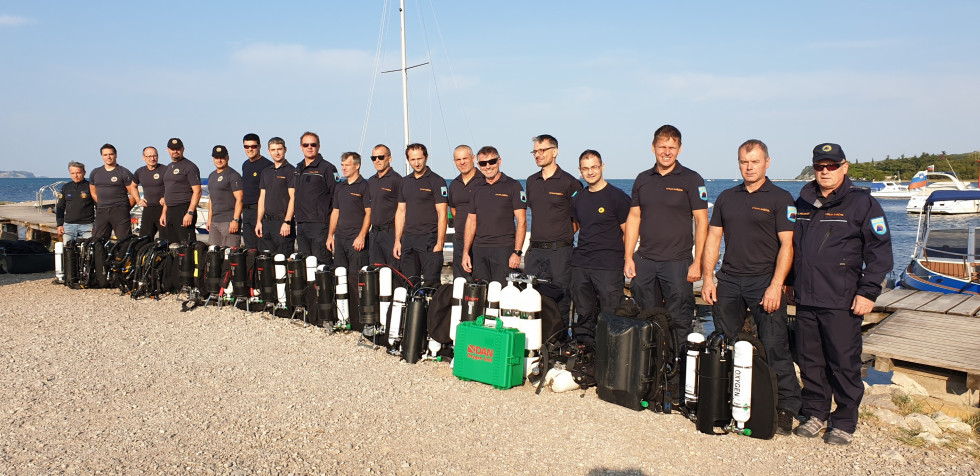 Enoto sestavljajo dva organizatorja usposabljanja, štirinajst pripadnikov enote in pet članov jamarske reševalne službe in jamarske zveze Slovenije. V ozadju morje.
