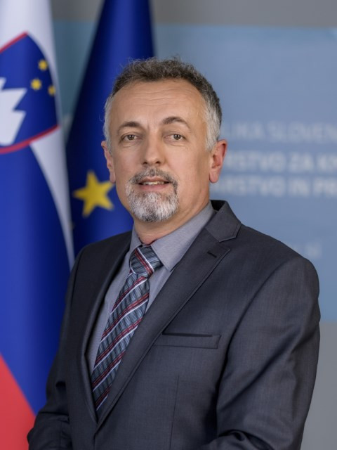 Matjaž Guček, v ozadju na levi slovenska in EU zastava