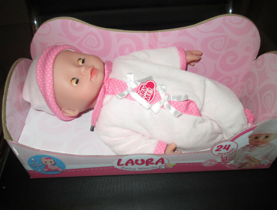 plastičen roza dojenček v belo roza oblačilih in kapico