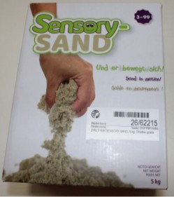 Embalaža igrače Sensory Sand (kinetični pesek) s prikazom peska, ki se pretaka skozi dlan. 
