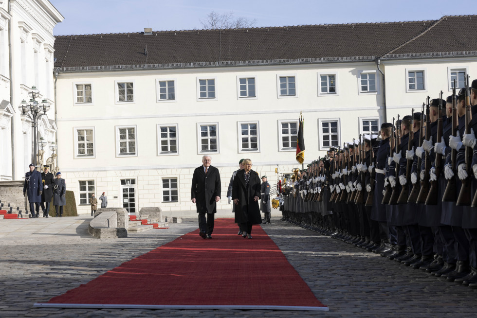 Die Präsidenten schreiten über den roten Teppich, mit der Ehrengarde zu ihrer Rechten und dem Schloss Bellevue im Hintergrund. 