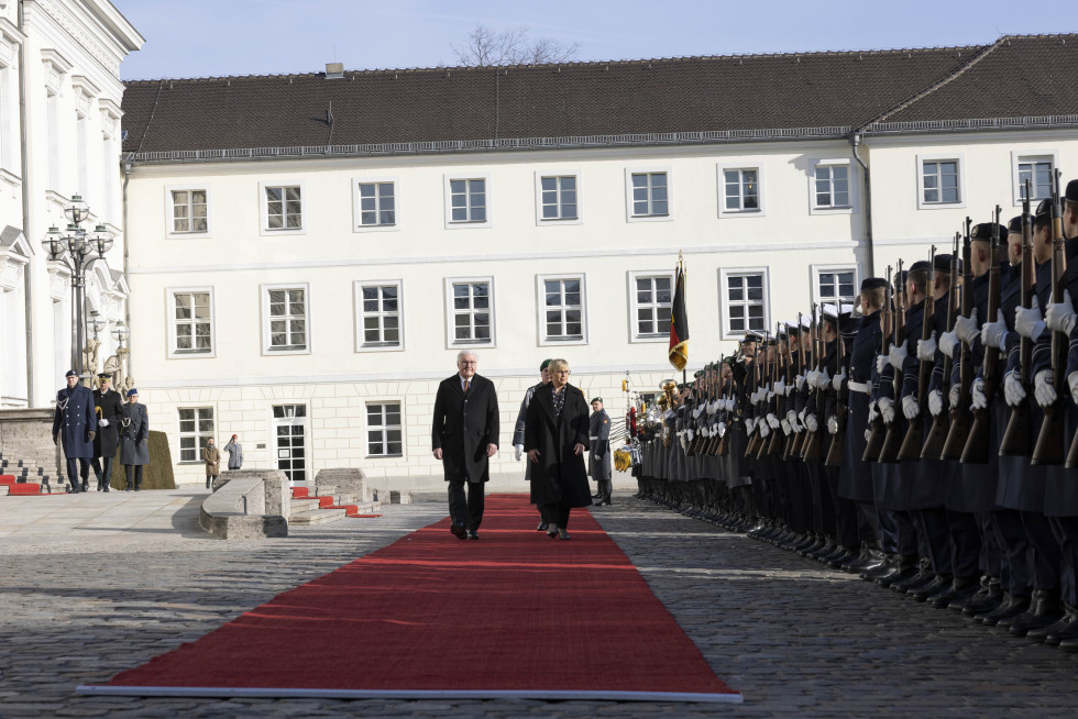 Die Präsidenten schreiten über den roten Teppich, mit der Ehrengarde zu ihrer Rechten und dem Schloss Bellevue im Hintergrund.