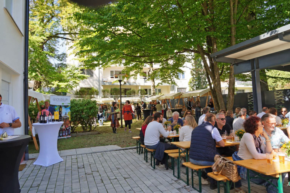 dvorišče v senci dreves, polno stojnic in ljudi