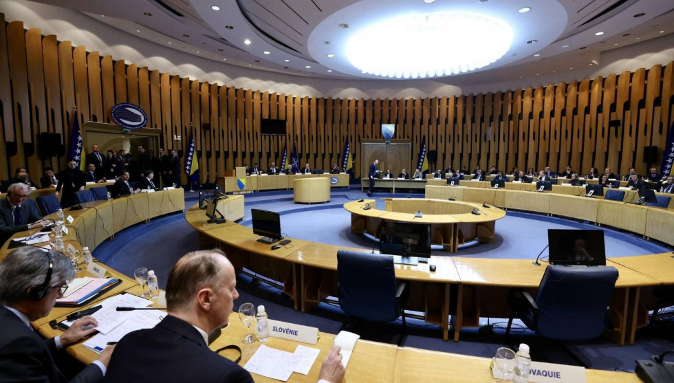 Sejan dvorana z veliko okroglo mizo za katero sedijo ljudje