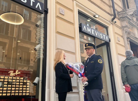 dve osebi držita šopek pred zidom s spominsko tablo