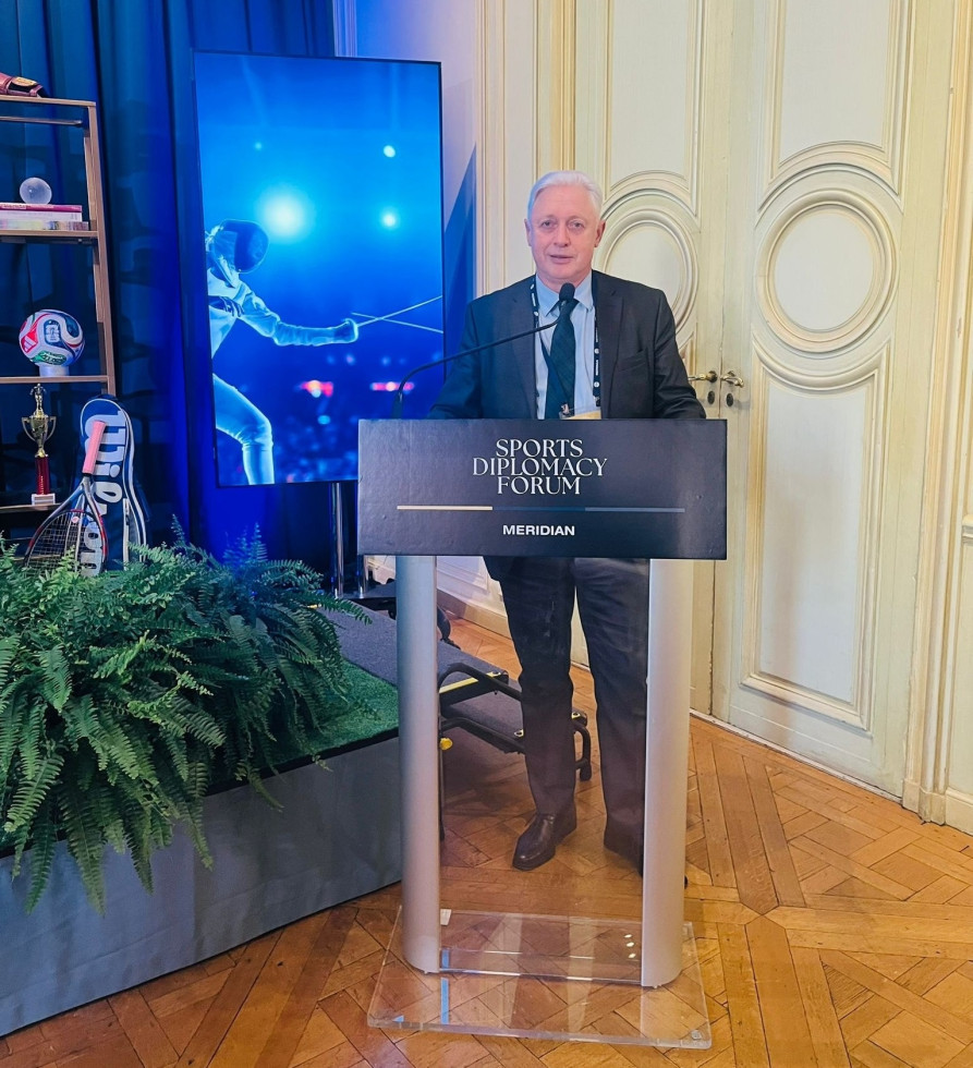 oseba stoji za govorniškim pultom