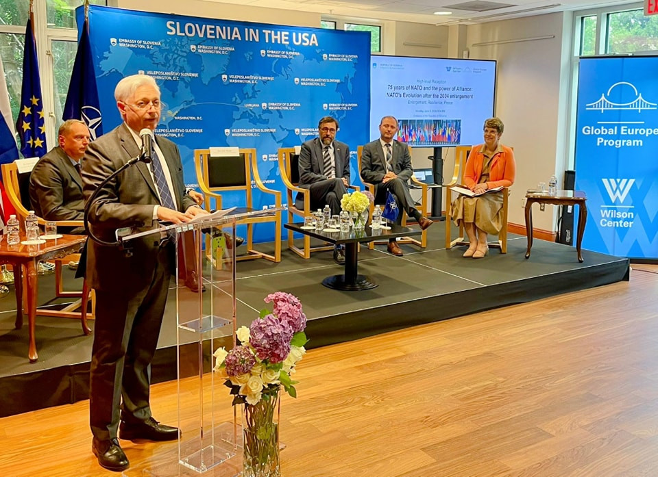 Veleposlanik Iztok Mirošič stoji pri govornici in nagovarja publiko.