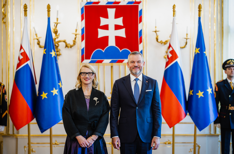 veleposlanica in predsednik pred zastavami