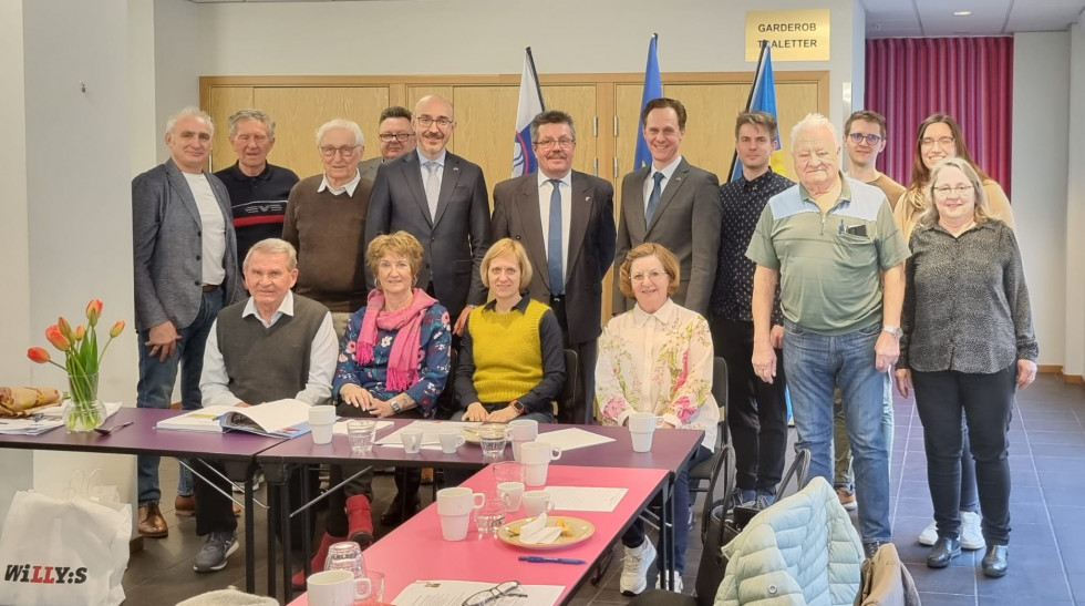 Participants in the General Assembly of the Slovenian Association in Sweden, some siting, others standing behind them 