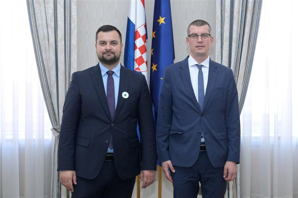 Poslanec Hodžić in veleposlanik Dovžan pred zastavami