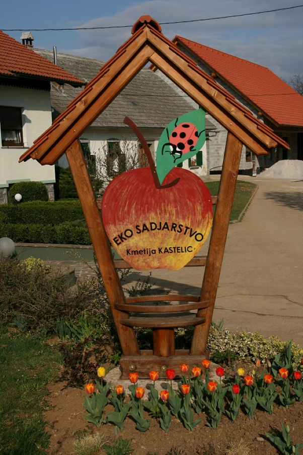 Tabla kmetije Kastelic z napisom: EKO SADJARSTVO Kmetija Kastelic.