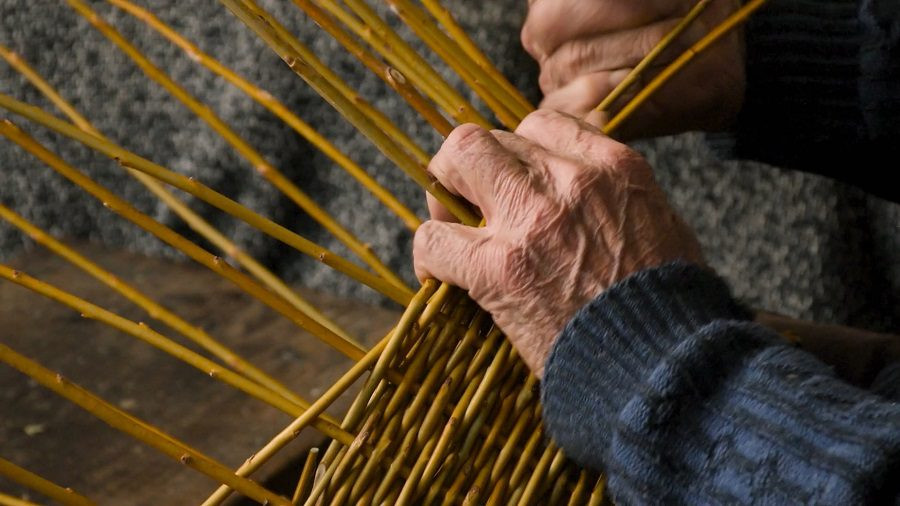Pogled na roke, ki pletejo košaro. 