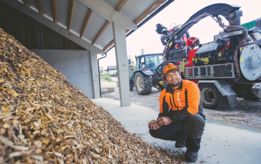 Na sliki je Peter Koren ob kupu lesnih sekancev.