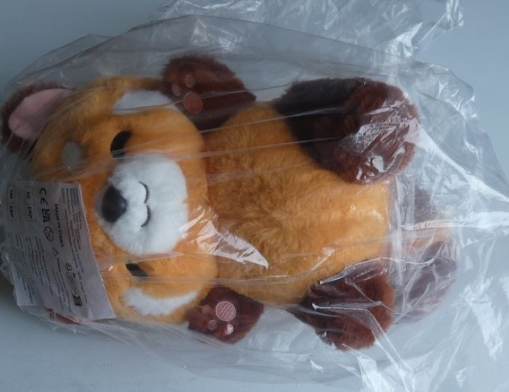 Plišasta igrača-Rdeča panda iz oranžnega in rjavega blaga z roza ušesi in z roza vezenino na tačkah in s črnimi očmi, belimi obrvmi ter plastičnim nosom.