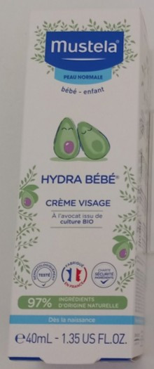 Embalaža hidratantne kreme. Embalaža je kartonska, bele barve z modrimi  napisi, nad imenom kreme sta narisana dva avokada, en z peško in en brez nje.