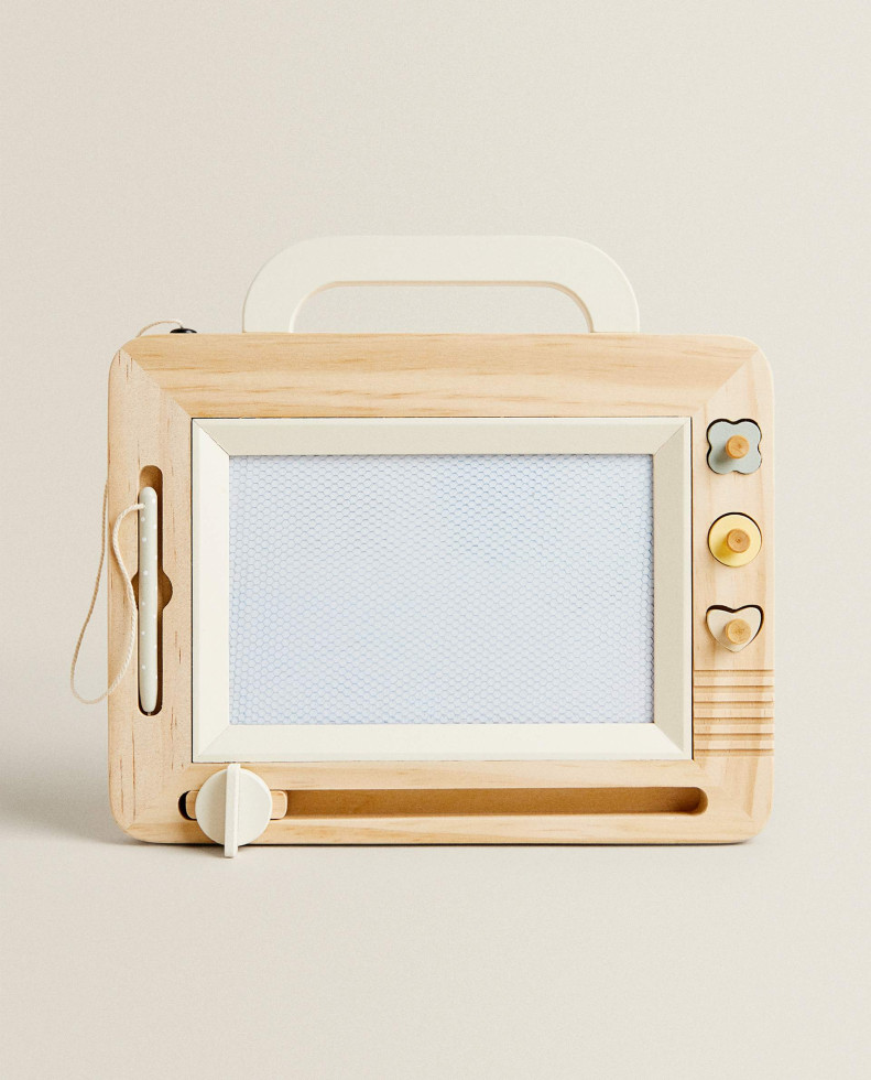 lesena igrača tablica v obliki kovčka oziroma starega radia s pisanimi gumbi v obliki srčka, rožice in kroga. Po tablici se riše/piše s priloženim svinčnikom. 