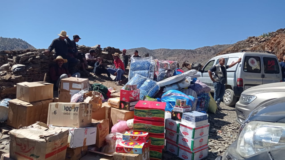 Na fotografiji so paketi pomoči (vzmetnice, hrana ...), ki jih je ekipa karitas pripeljala lokalnim prebivalcem v porušeno naselje. 