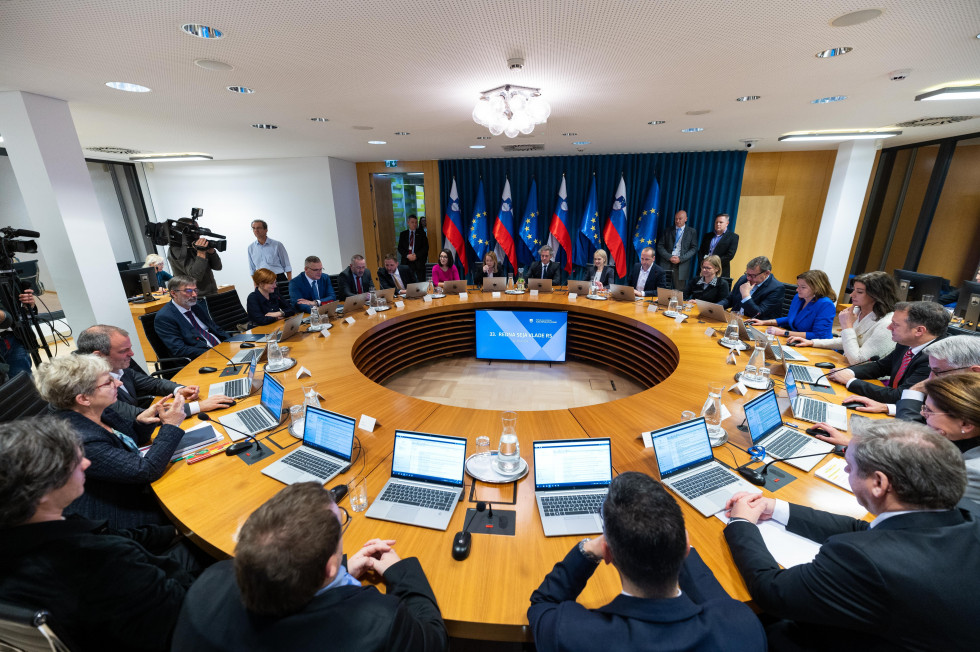 room with flags and people sitting around the round table