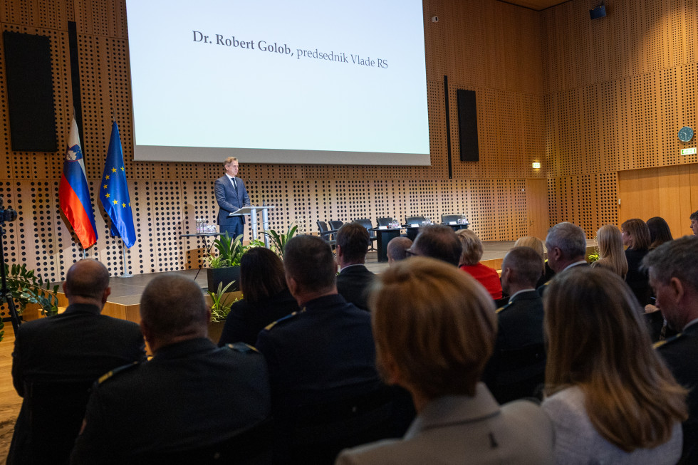 Predsednik vlade za govornico nagovarja udeležence