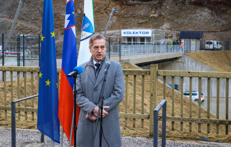 P SVL Gorenjska 10022026 (Robert Golob is standing, with flags on the left and a bridge behind him.)