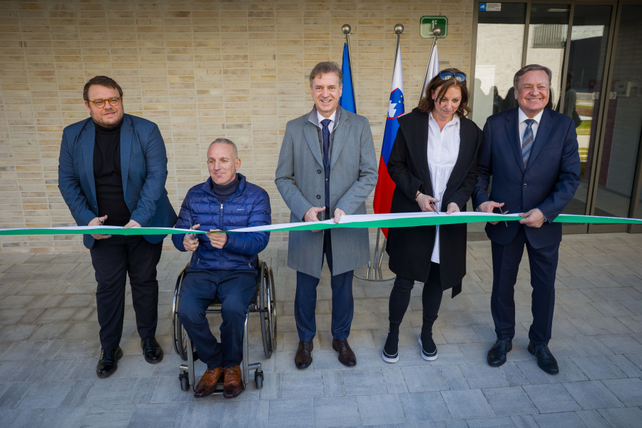 Osebe s škarjami režejo slavnosti trak