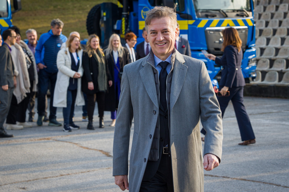 Robert Golob hodi, v ozadju so ljudje in gasilsko vozilo.