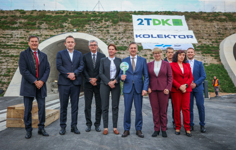 PV drugi tir 1 11032026 (Robert Golob, Alenka Bratušek, and the delegation stand in front of the tunnel. Robert Golob holds a signal sign in his hands.)