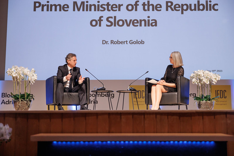 Prime Minister and interviewer on stage in front of a screen