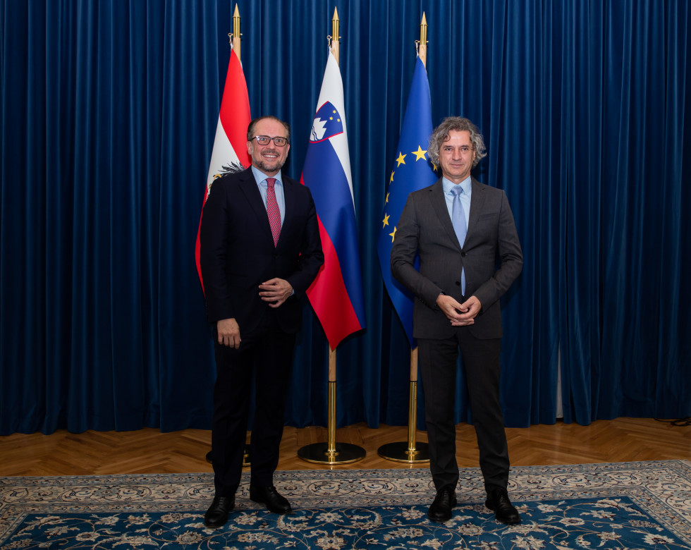 Predsednik vlade dr. Robert Golob in avstrijski minister za evropske in mednarodne zadeve Alexander Schallenberg pred zastavami