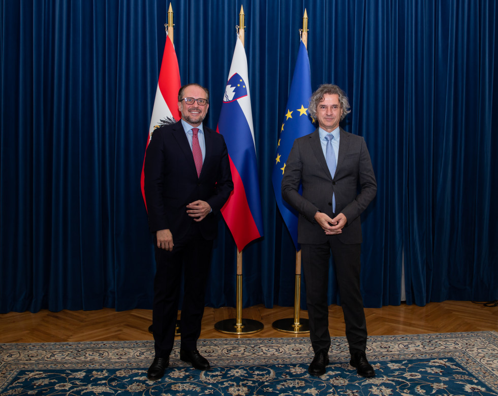 Predsednik vlade dr. Robert Golob in avstrijski minister za evropske in mednarodne zadeve Alexander Schallenberg pred zastavami