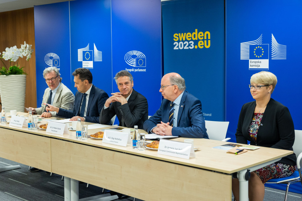 Predsednik vlade sedi za mizo, skupaj z veleposlanikom Švedske in vodjo predstavništva Evropske komisije v Sloveniji