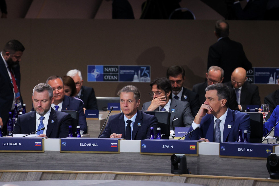 Predsednik vlade sedi za mizo med slovaškim in španskim premierjem