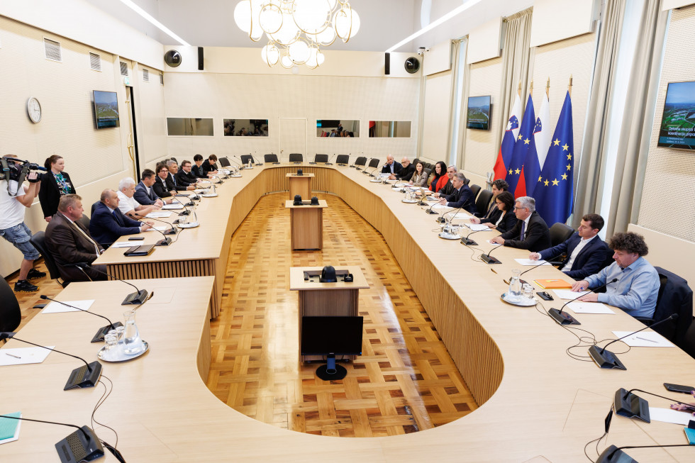 Participants in a working group meeting on a new nuclear power plant sit around a large oval table.