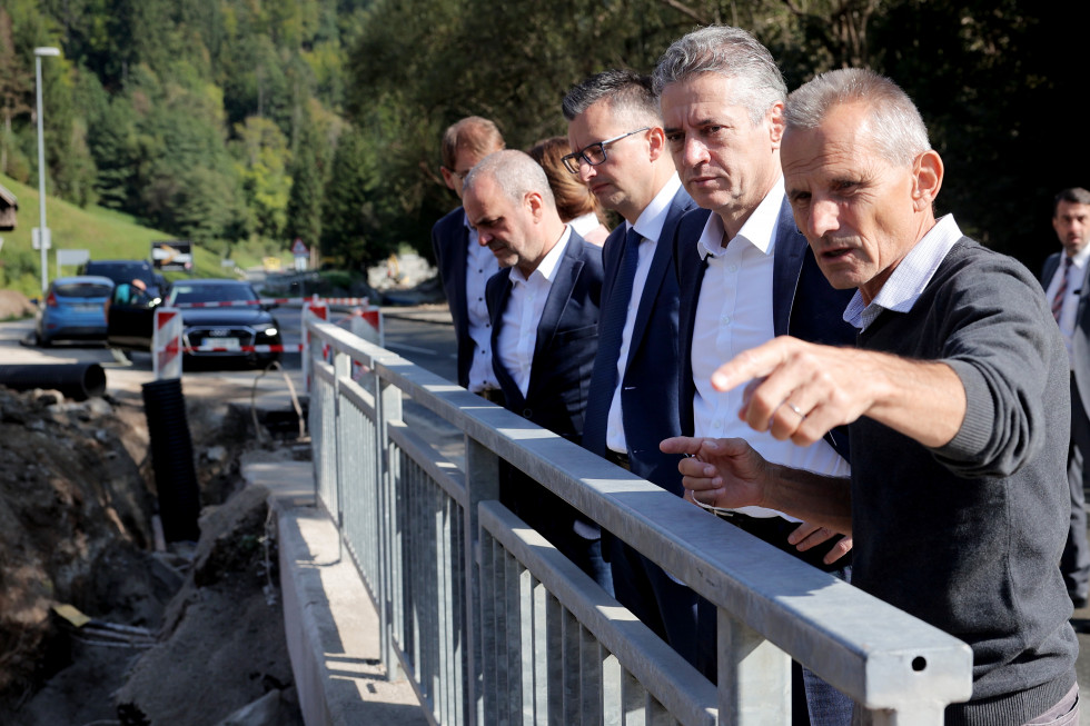 Predsednik vlade Robert Golob si v družbi ministrov in župana Prevalj ogleduje škodo po poplavah.