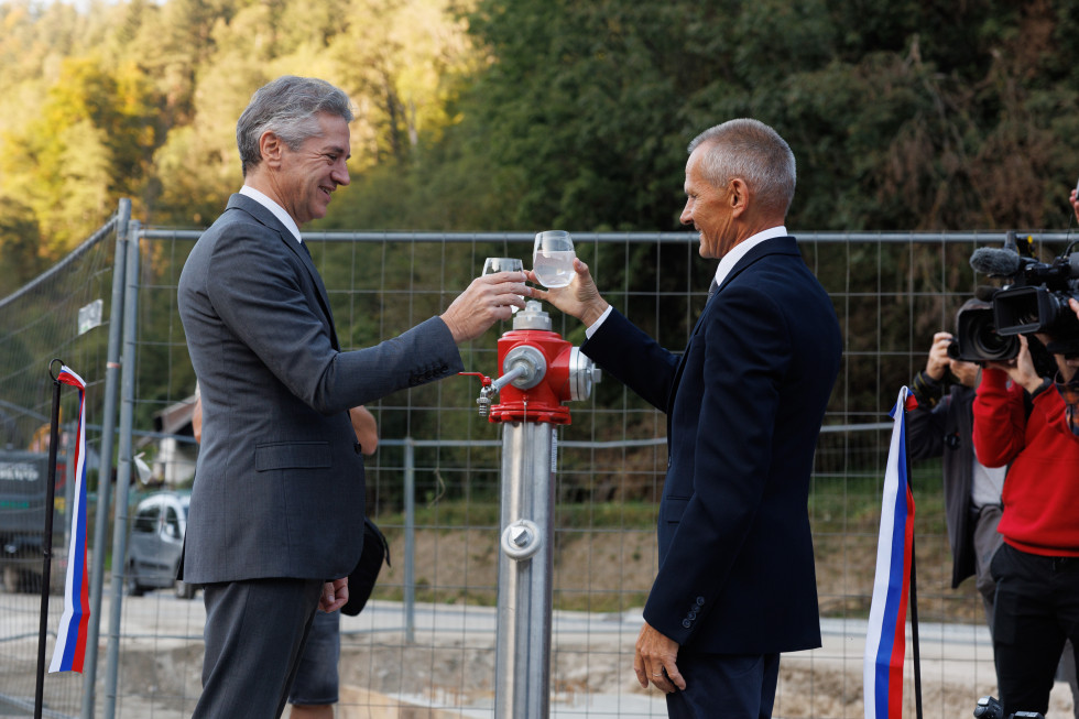Prime Minister Robert Goloba and Mayor of Prevalje Municipality Matija Tasič poured water from the pipeline into a glass