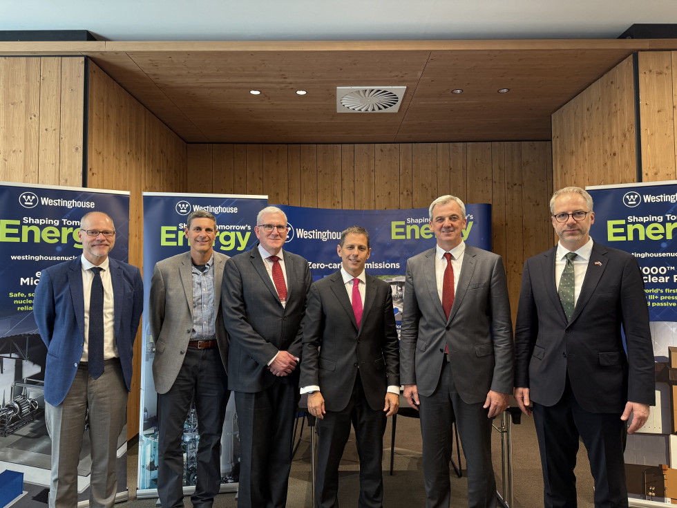 Skupina moških stoji in se fotografira. Za njimi so ozadja konference Nuclear Energy for New Europe