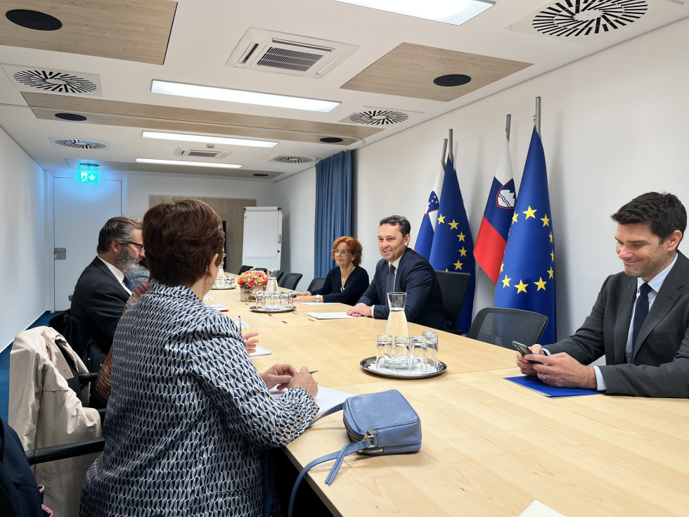 Udeleženci sestanka sedijo za mizo drug nasproti drugemu