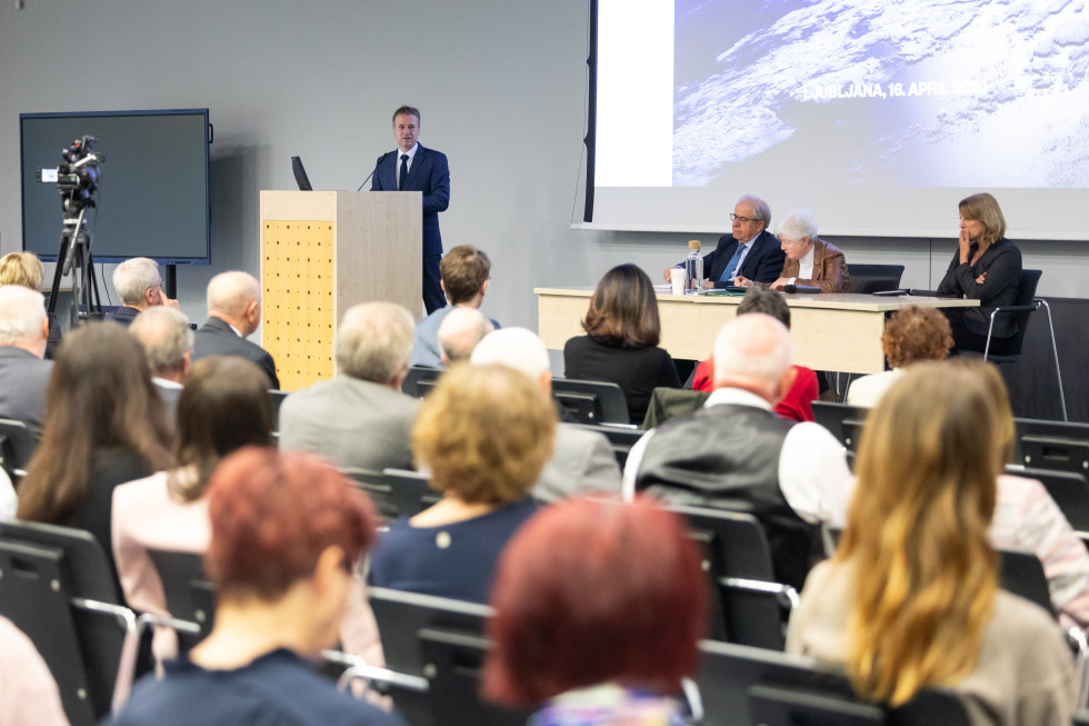 Prime Minister Robert Golob behind a lectern addressing the audience in the hall